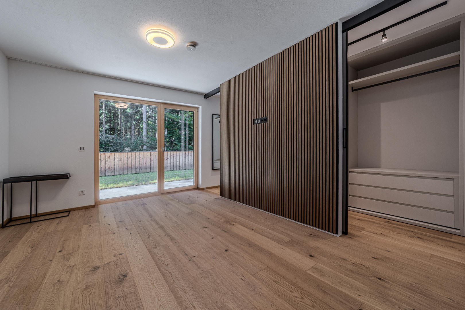 Schlafbereich mit Eichenlamellenwand und offener Ankleide