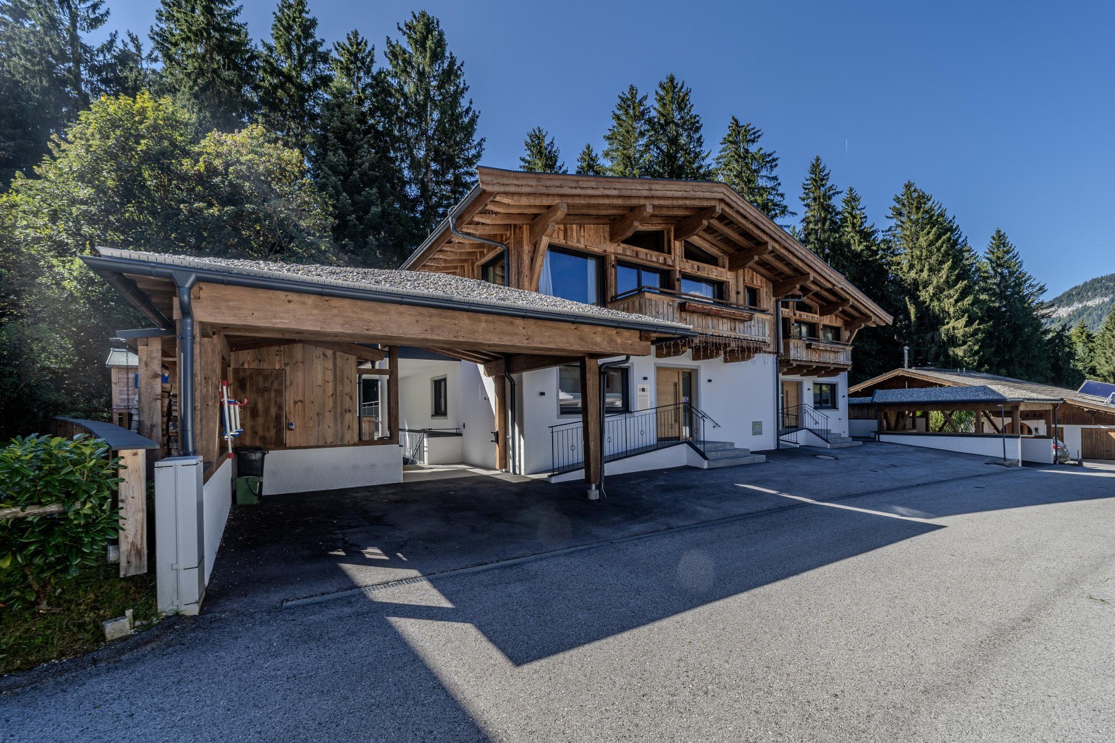 Einfahrt in die private Sackgasse – Altholzfassade und Balkone