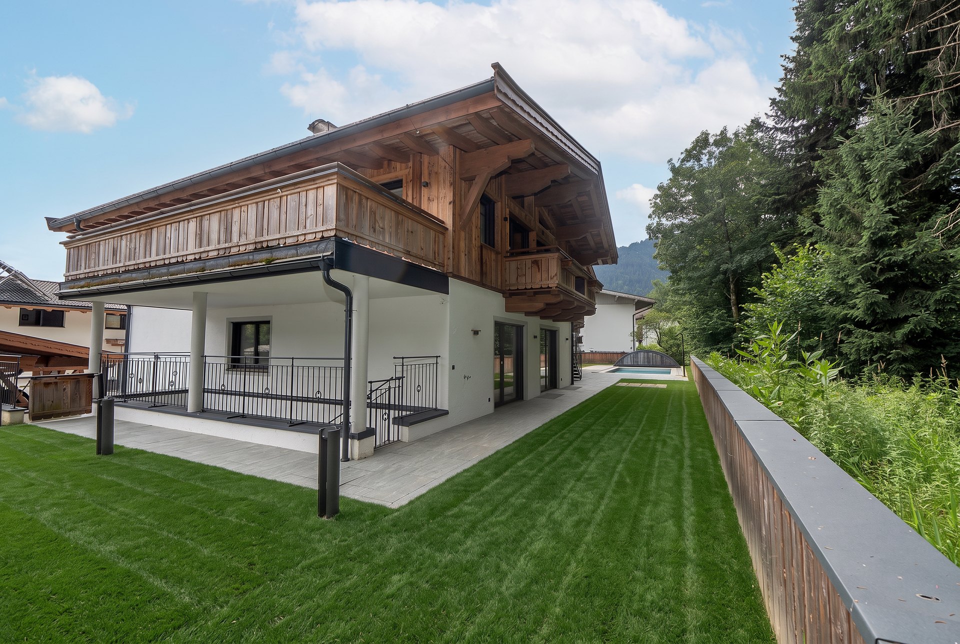 Gartenseite mit überdachter Terrasse und Poolbereich