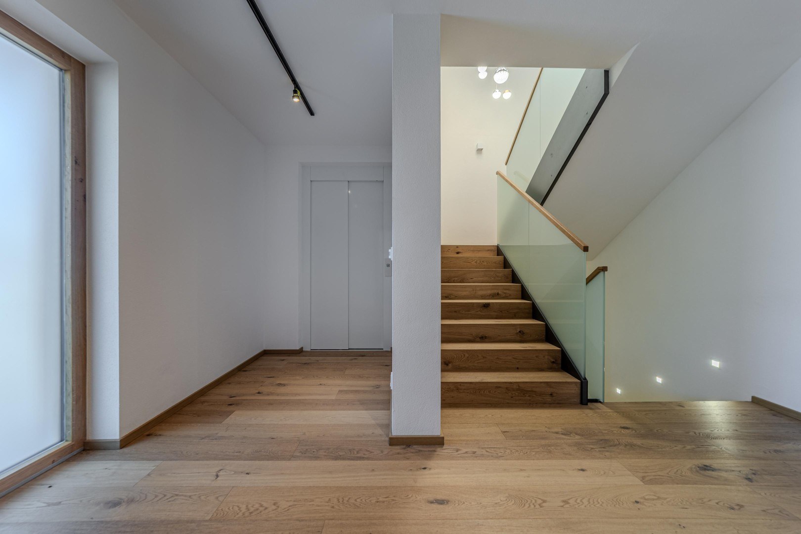 Treppenaufgang mit Glasbrüstung und Eichenstufen