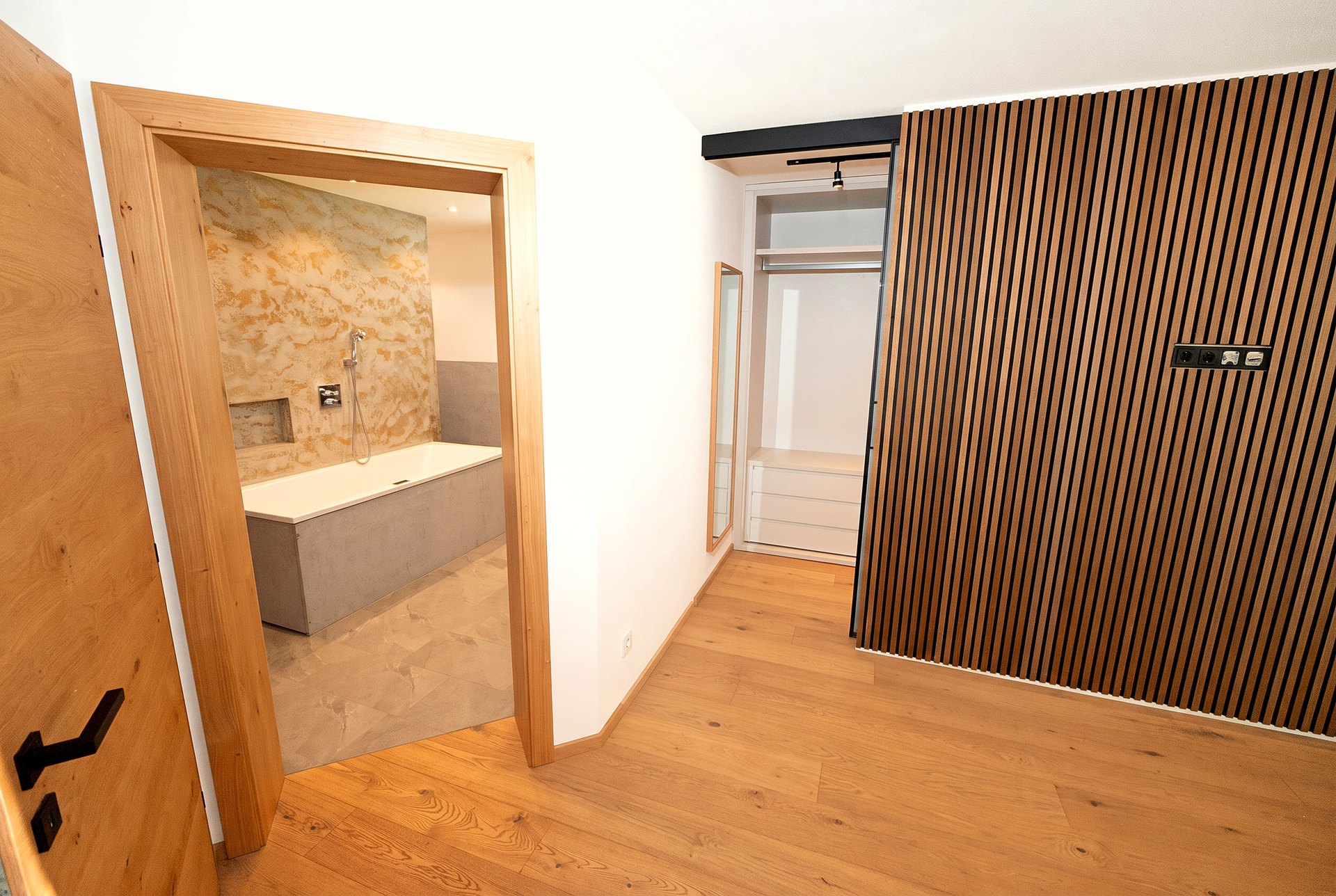 Blick vom Schlafbereich in das Bad mit freistehender Wanne