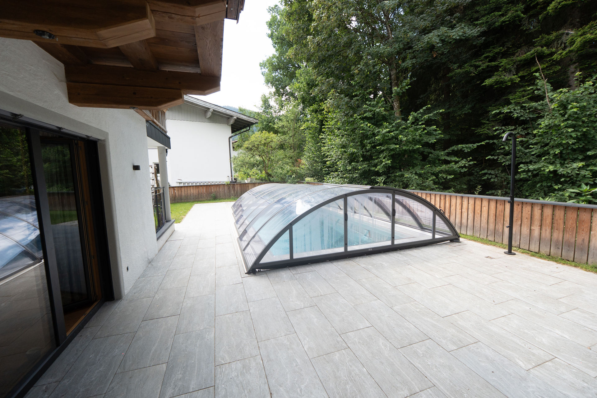Terrasse mit Außenpool und Blick in den angrenzenden Wald