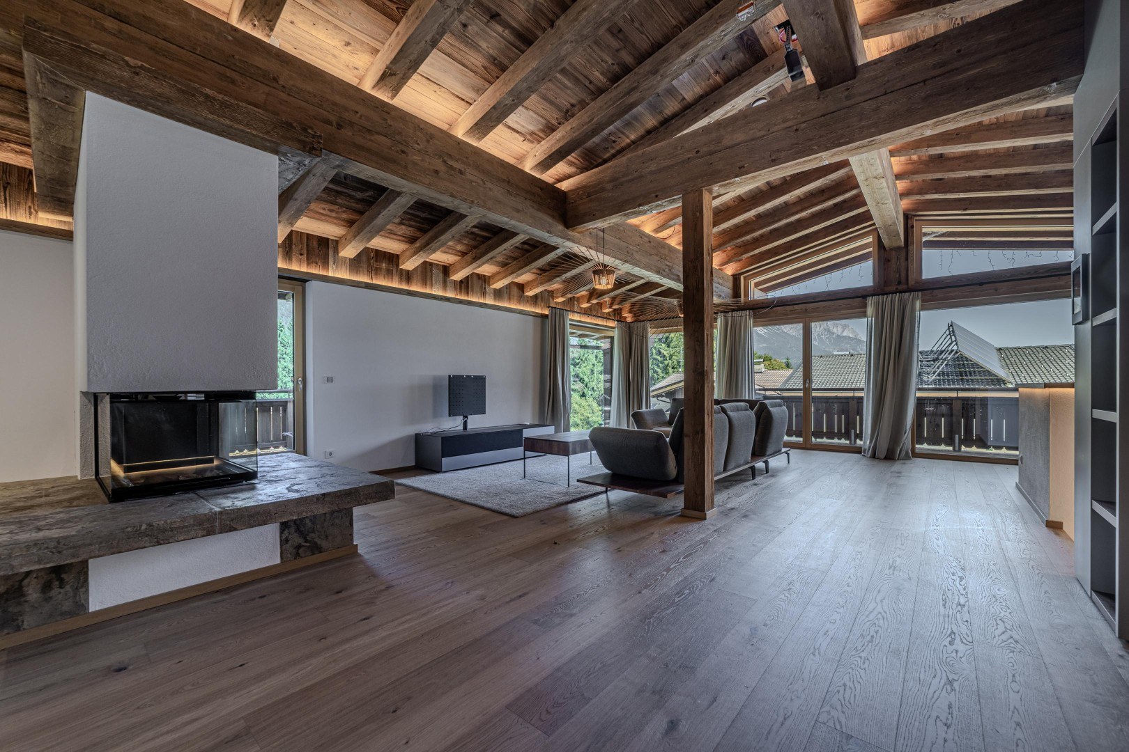 Wohnraum mit offenem Kamin und Panoramaverglasung